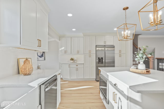 kitchen featuring stainless steel appliances, white cabinetry, an inviting chandelier, and pendant lighting