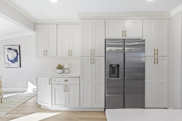 kitchen with stainless steel fridge, crown molding, light hardwood / wood-style floors, and white cabinetry