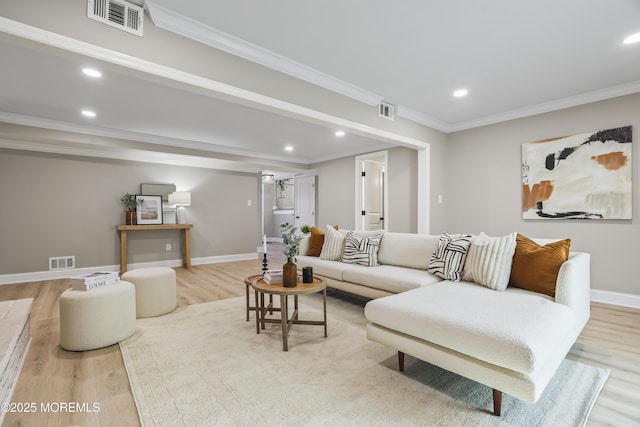 living room with light hardwood / wood-style floors and crown molding