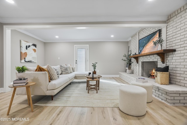 living room with ornamental molding, light hardwood / wood-style flooring, and a fireplace