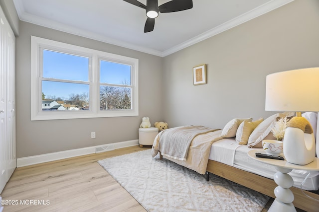 bedroom featuring ceiling fan, light wood-type flooring, ornamental molding, and a closet