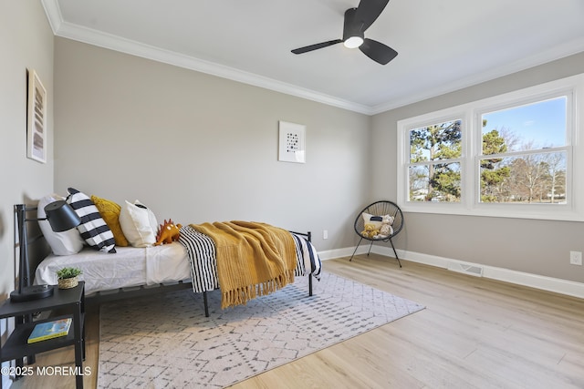 bedroom featuring ceiling fan, light hardwood / wood-style floors, and ornamental molding