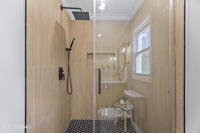 bathroom with a shower with door and crown molding