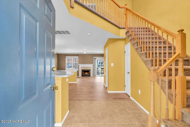 entrance foyer featuring a tiled fireplace and light tile patterned floors