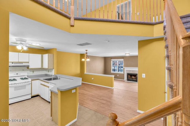 kitchen featuring sink, tasteful backsplash, range hood, white cabinets, and white stove