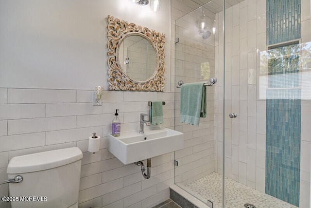 bathroom with walk in shower, sink, tile walls, and toilet