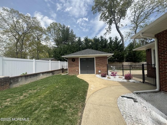 view of yard with a fenced backyard, an outdoor structure, and a gate