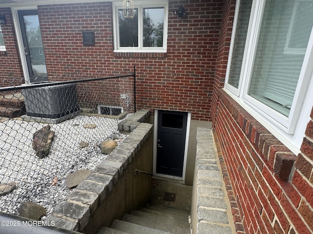 exterior space featuring cooling unit and brick siding