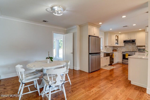 dining space featuring ornamental molding, visible vents, recessed lighting, baseboards, and light wood-style floors