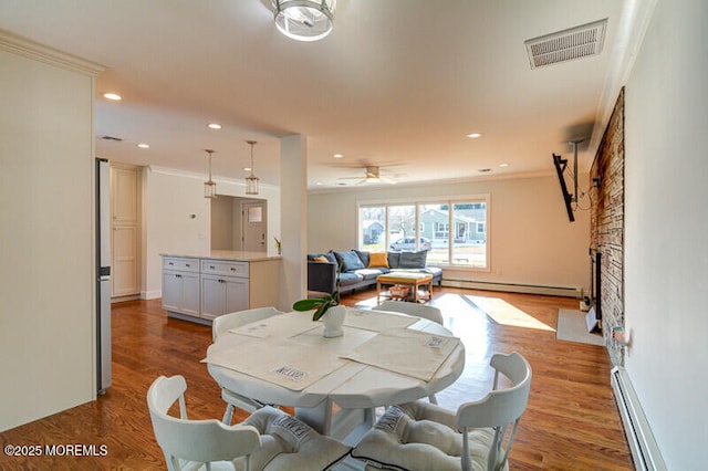 dining area featuring visible vents, a baseboard radiator, and ornamental molding