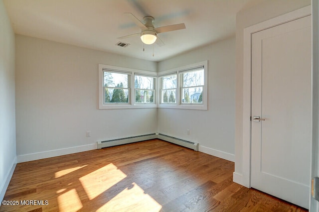 empty room featuring baseboards, a baseboard heating unit, visible vents, and ceiling fan