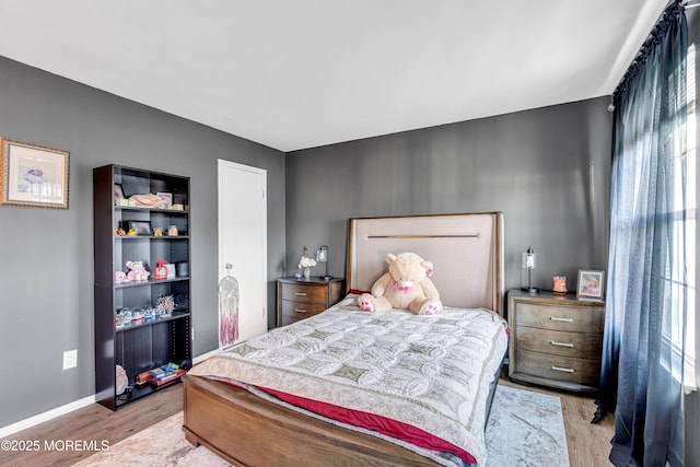 bedroom featuring multiple windows and light hardwood / wood-style flooring