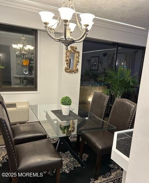 dining area featuring a wall mounted AC, a textured ceiling, ornamental molding, and an inviting chandelier