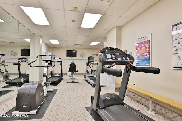 gym with a paneled ceiling and carpet