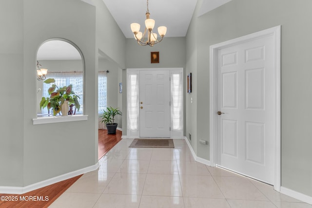 tiled entrance foyer with an inviting chandelier