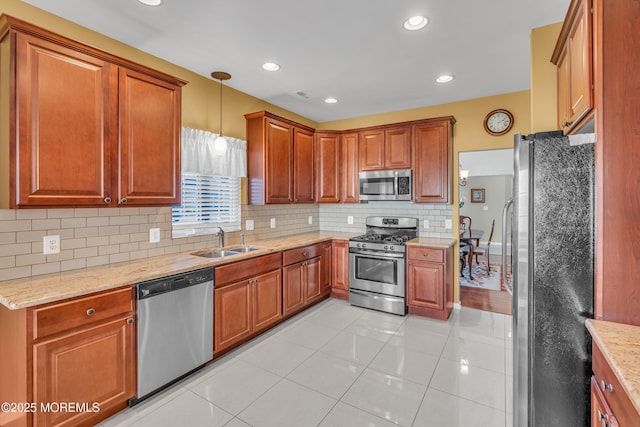 kitchen with decorative light fixtures, tasteful backsplash, sink, light tile patterned flooring, and stainless steel appliances