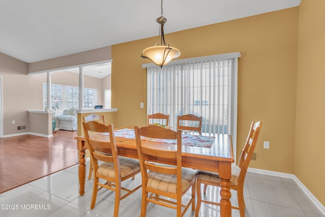 tiled dining room with lofted ceiling