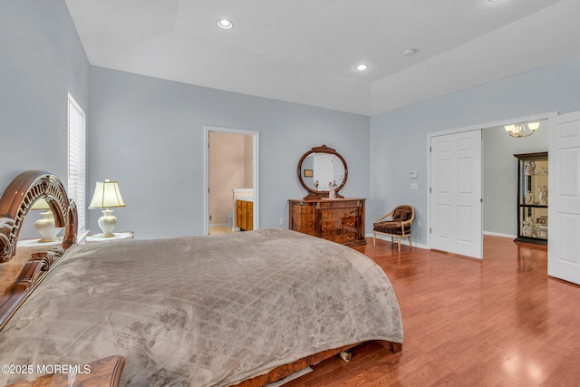 bedroom with vaulted ceiling and hardwood / wood-style flooring