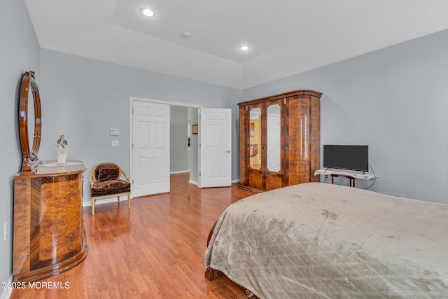 bedroom with lofted ceiling and light hardwood / wood-style flooring