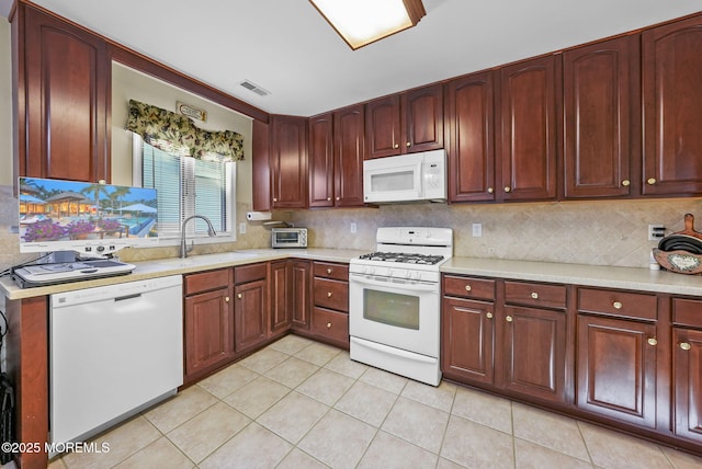 kitchen featuring white appliances, decorative backsplash, sink, and light tile patterned floors