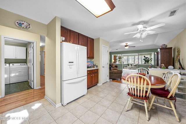 kitchen featuring washing machine and clothes dryer, ceiling fan, light tile patterned floors, and white refrigerator with ice dispenser