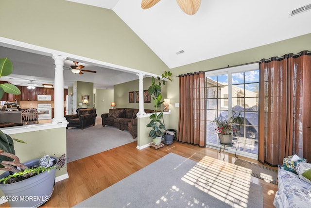 entryway with light wood-type flooring, vaulted ceiling, and decorative columns