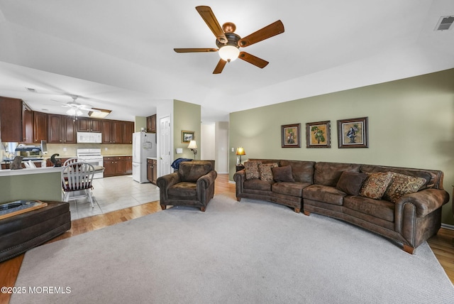 living room featuring ceiling fan and light hardwood / wood-style floors