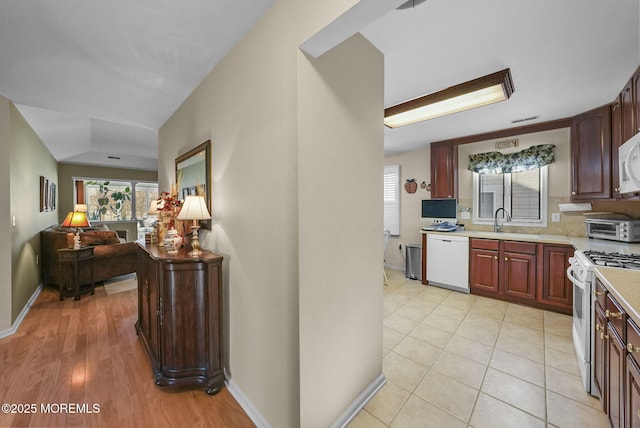 kitchen with white appliances, light hardwood / wood-style flooring, and sink