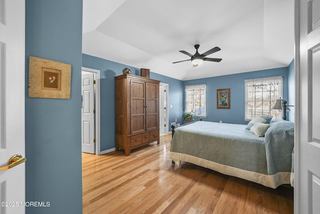 bedroom with vaulted ceiling, ceiling fan, and light hardwood / wood-style floors