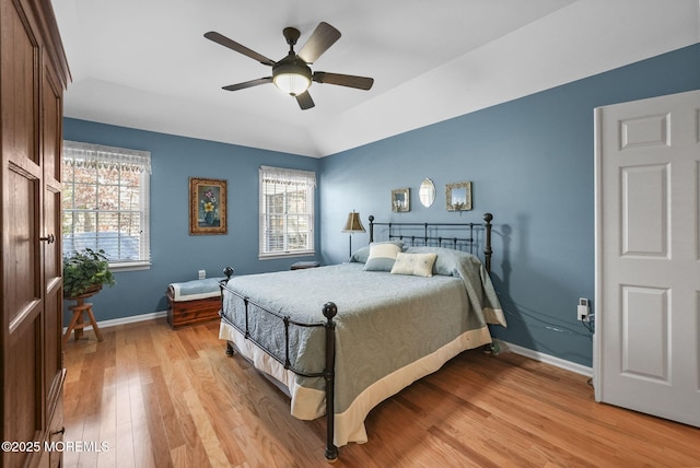 bedroom featuring ceiling fan, light wood-type flooring, multiple windows, and lofted ceiling