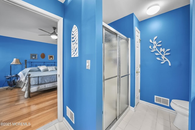 bathroom featuring toilet, walk in shower, and ceiling fan