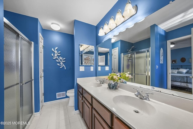 bathroom with toilet, an enclosed shower, and vanity