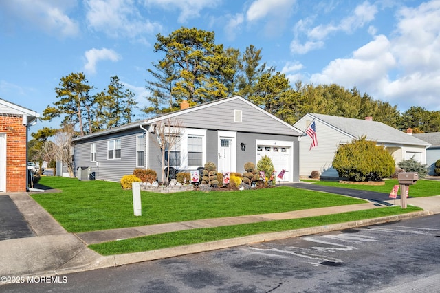 view of front of property featuring a front yard, a garage, and cooling unit