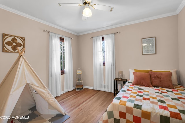 bedroom featuring a ceiling fan, light wood-type flooring, crown molding, and baseboards