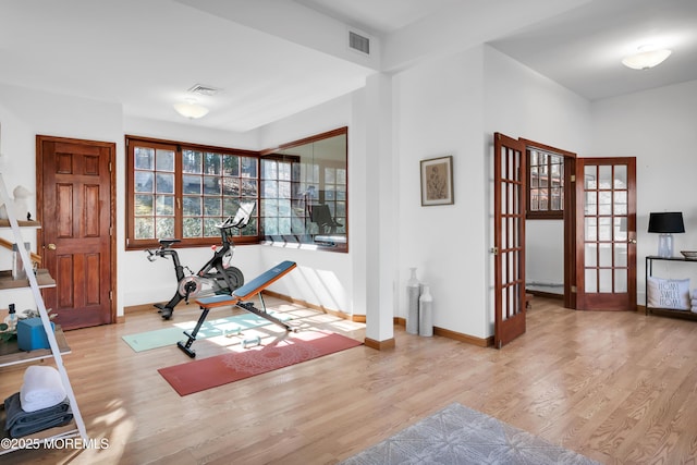 workout area with french doors, visible vents, baseboards, and wood finished floors