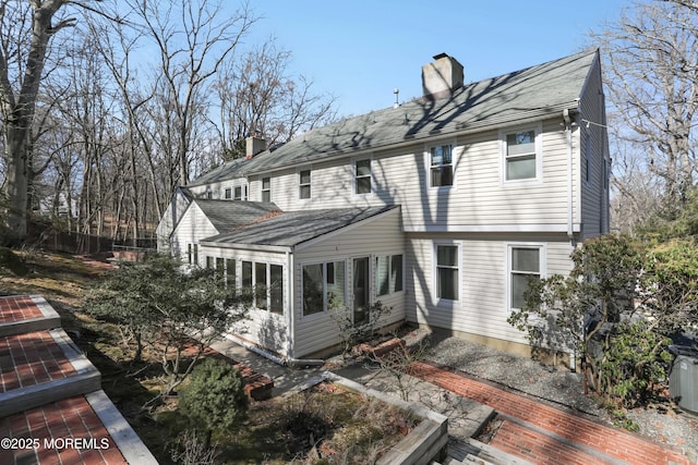 rear view of house featuring a chimney