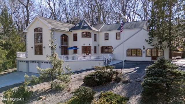 view of front of home featuring driveway, a chimney, and stucco siding