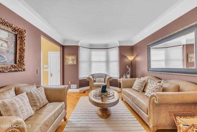 living room with light hardwood / wood-style floors, ornamental molding, and a wealth of natural light