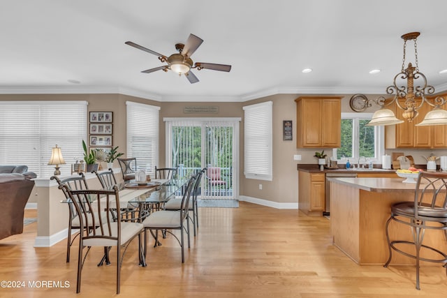 kitchen featuring dishwasher, decorative light fixtures, light hardwood / wood-style floors, ceiling fan with notable chandelier, and ornamental molding