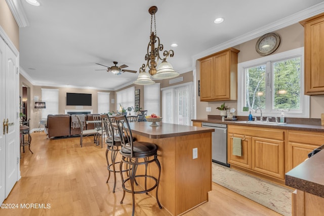 kitchen with sink, a center island, ceiling fan, stainless steel dishwasher, and crown molding