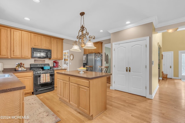 kitchen featuring black appliances, decorative light fixtures, crown molding, and a kitchen island