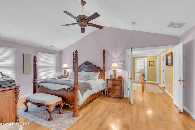 bedroom with ceiling fan, light hardwood / wood-style floors, and vaulted ceiling