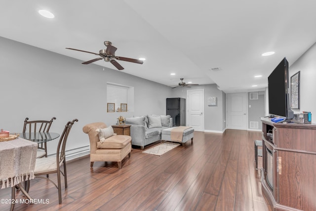 living room featuring ceiling fan, dark hardwood / wood-style flooring, and a baseboard heating unit