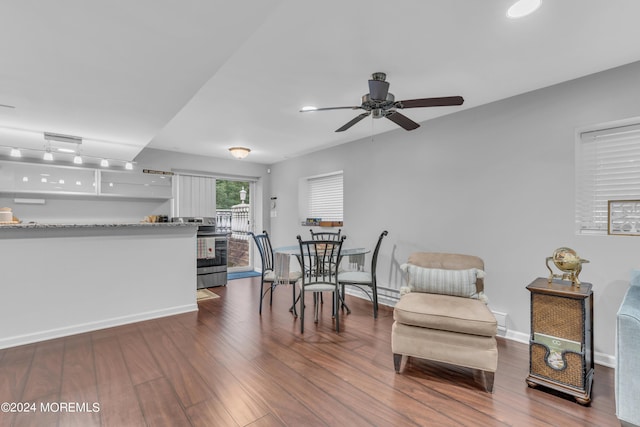 dining area with dark wood-type flooring and ceiling fan