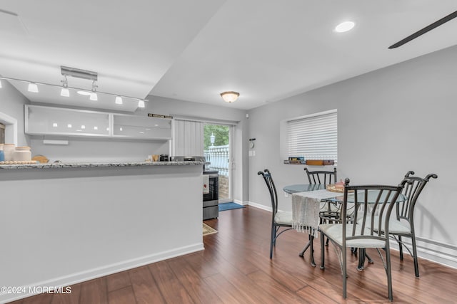 kitchen featuring dark hardwood / wood-style flooring, white cabinetry, light stone counters, and stainless steel range oven