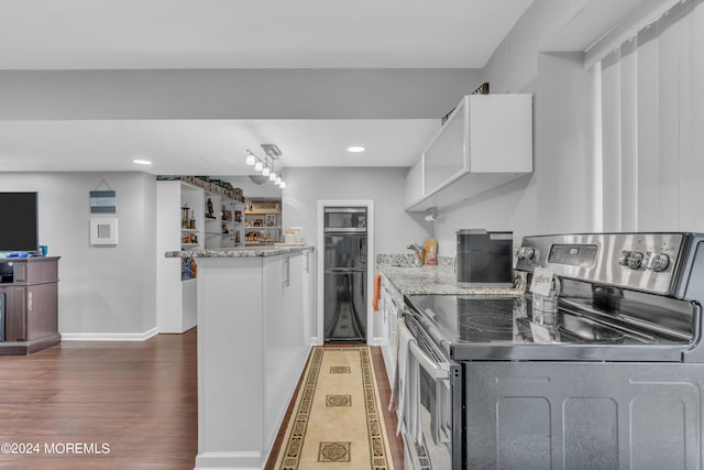 kitchen with white cabinets, electric stove, light stone counters, and dark hardwood / wood-style floors