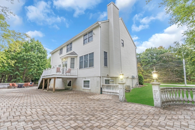 rear view of property with a patio area, central AC, and a wooden deck