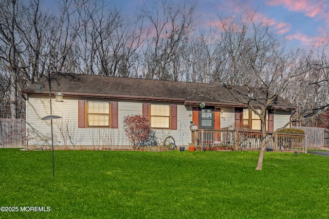 back house at dusk with a lawn