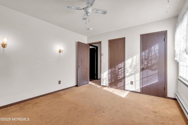 carpeted empty room with baseboard heating and ceiling fan