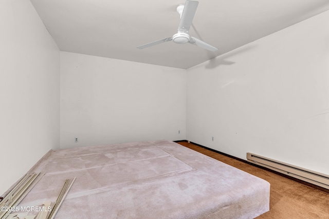 carpeted spare room with ceiling fan and a baseboard radiator